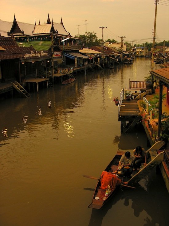 Traditional Thai teak houses along peaceful canal